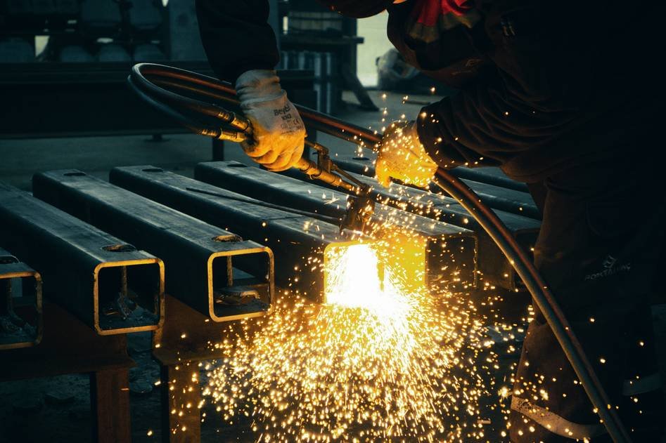 Close-up of plasma cutter torch with metal sparks flying